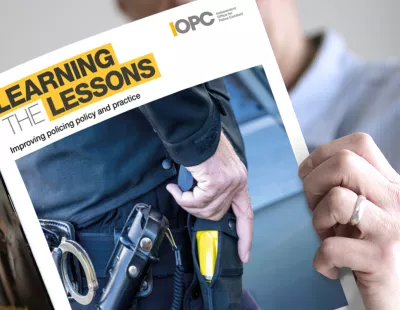 Person reading Learning the Lessons issue 47 magazine. Front cover is in shot